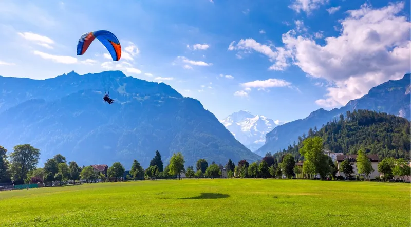 The Höhematte landing field with paragliders coming in over Interlaken