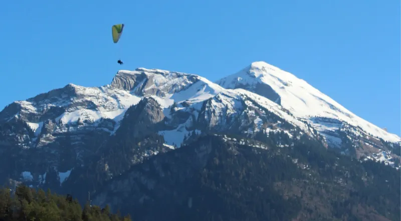 Paraglider with the snow-capped peaks of the Jungfrau region behind
