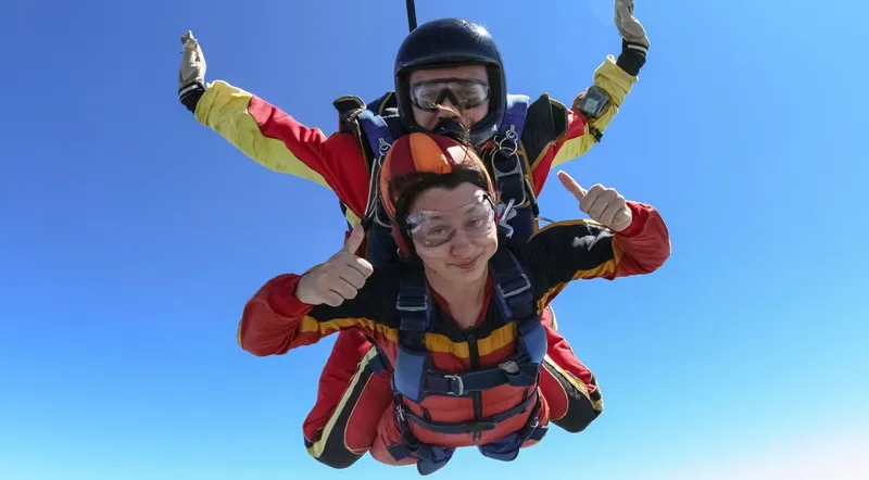 Tandem skydiving pair with the Interlaken landscape far below